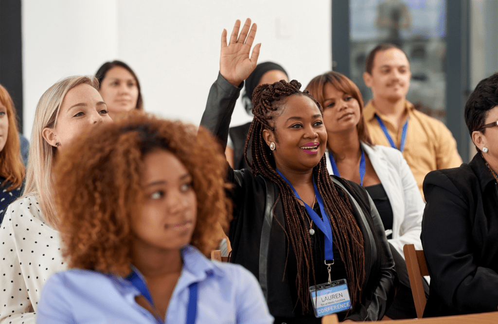 Woman raises her hand to participate in a Schwartz Rounds session