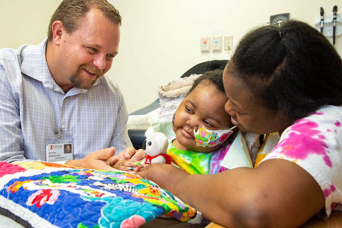 Doctor and mother hold hands with pediatric patient in a hospital